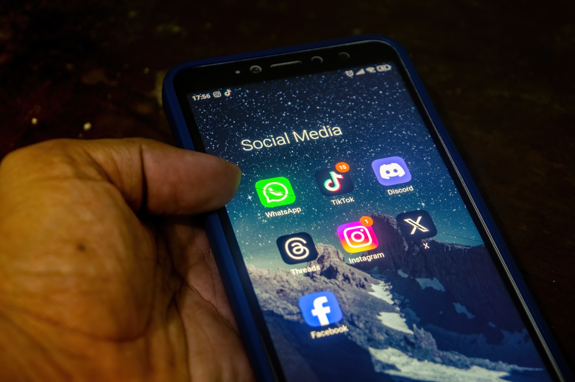 Mano sosteniendo un celular con WhatsApp y otras apps de mensajería — el canal personal que destruye la operación del salón.