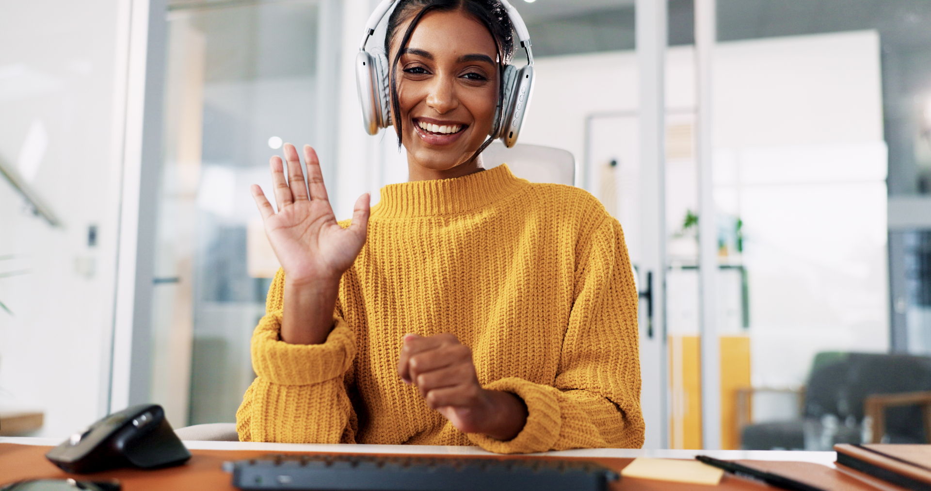Recepcionista virtual sonriendo con audífonos mientras atiende clientes de un salón de belleza.